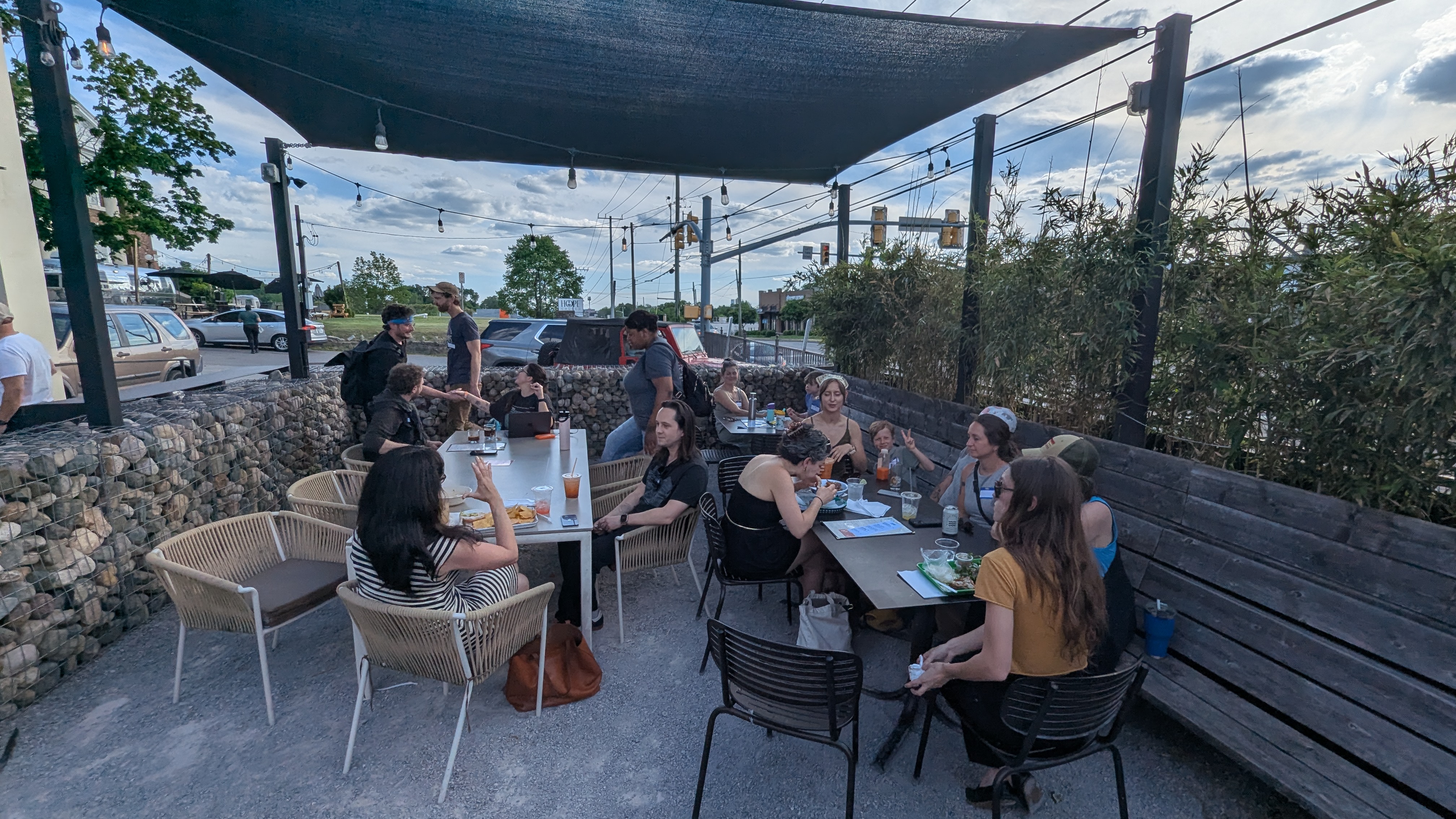 Neighbors sitting around tables talking at an outdoor evening gathering